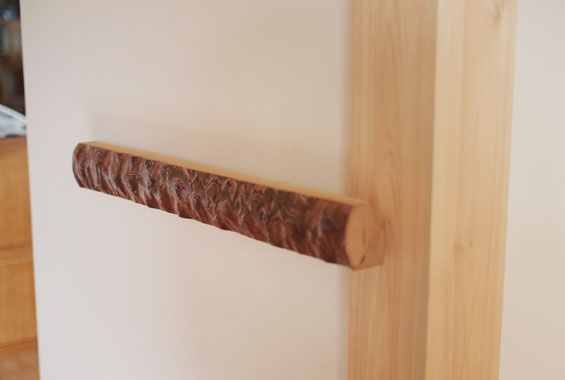 ※写真：玄関の手すりは、以前の家で「床柱」として使われていた木を使ってつくりました。